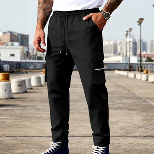 Detalle de pantalones cargo negros para hombre con bolsillo con cremallera y cordón.