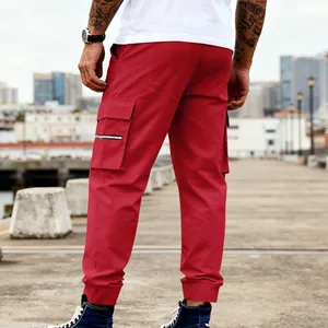 Vista trasera detallada de pantalones cargo rojos para hombre con bolsillos laterales.
