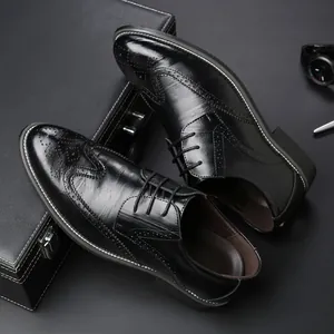 Classic black men's leather business dress shoes with elegant wingtip brogue patterns