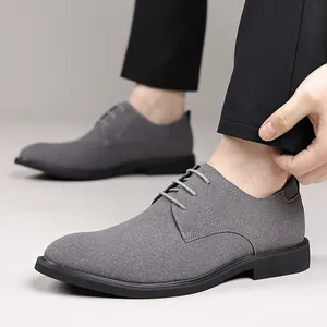 Close-up view of grey textured leather men's British style casual dress shoes on feet
