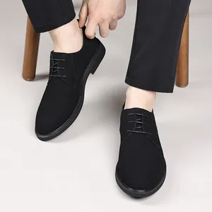 Detailed macro view of men's professional black matte pointed-toe lace-up dress shoes