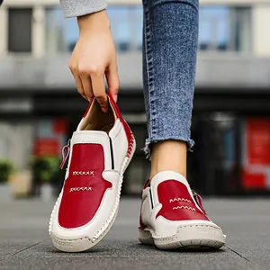 Primo piano di scarpe slip-on in pelle rossa e bianca con suole cucite a mano