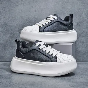 Detail shot of black and white shell-toe sneakers with thick soles and pebbled leather.