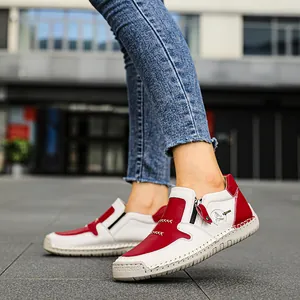 Dettaglio di eleganti stivaletti in pelle rossa e bianca con cerniera e cuciture