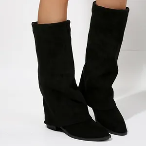 Close-up of black suede fold-over boots featuring a stylish shark lock design