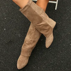 Macro view of khaki suede slouchy boots with a pointed toe and chunky low heel.