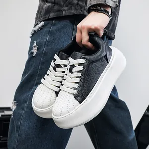 Close-up view of stylish men's chunky black leather sneakers with white shell toe design.