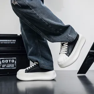 Close-up detail of men's chunky shell-toe sneakers styled with baggy denim jeans
