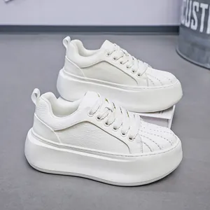 Detail view of white shell toe thick-soled platform sneakers for men with faux leather texture.