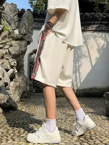Side view of white men's ethnic style linen shorts with colorful woven side stripes