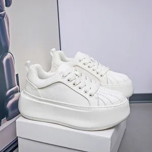 Detailed view of white thick-sole sneakers with a stylish shell-toe design and textured upper
