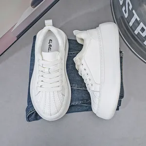Detailed view of white platform sneakers with shell-toe design and thick soles