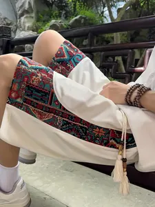 Detailed view of men's breathable ethnic shorts with vibrant pattern and tassel drawstrings