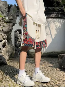 Detail of men's linen shorts featuring colorful ethnic patterns and drawstring tassels