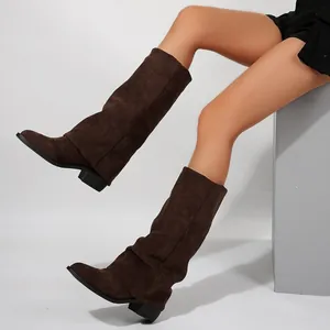 Close-up detail of stylish brown suede mid-calf boots featuring stable block heels