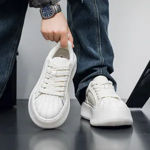 Detailed view of white shell-toe sneakers with thick soles and textured leather upper