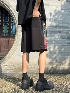 Detailed back view of men's black ethnic leisure shorts featuring colorful side patterns