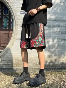 Detail view of men's ethnic style black shorts with vibrant colorful patterned panels