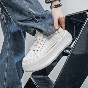 Close-up of white shell toe platform sneaker with textured leather on black steps.