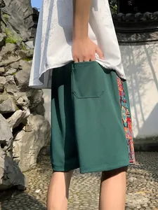 Detail of men's green ethnic linen shorts featuring a vibrant tribal side pattern design
