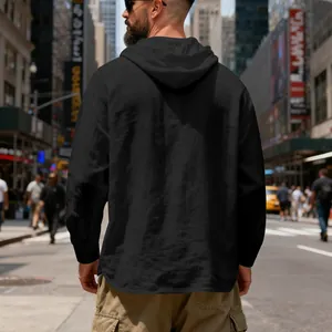 Vue de dos d'un sweat à capuche noir en lin pour homme dans une rue de la ville