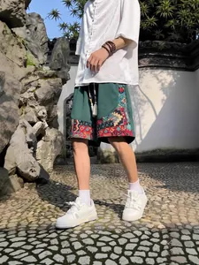 Men's ethnic style linen casual shorts in deep green with colorful geometric print patterns