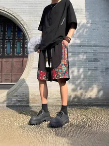 Men's ethnic style loose linen shorts featuring colorful geometric pattern side panels