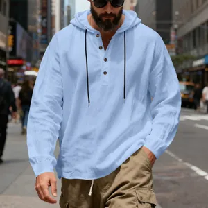 Chemise Henley à capuche en lin bleu clair portée par un mannequin en milieu urbain