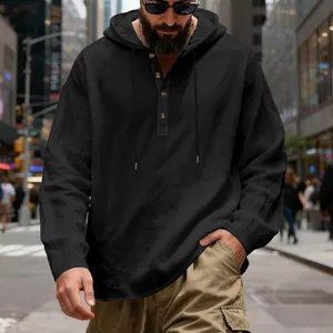 Close-up detail of men's loose black linen hooded shirt with classic Henley neck.