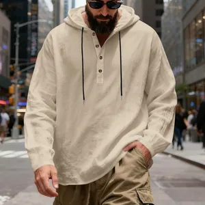 Detailed shot of men's loose beige linen hooded henley shirt with black drawstrings.