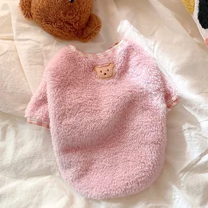 Close-up of soft pink fleece pet sweater featuring cute bear embroidery and checkered trim.
