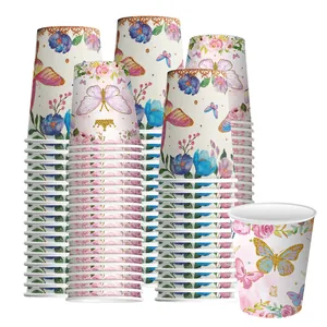 Détail de gobelets en papier jetables avec motifs papillons dorés et fleurs roses.