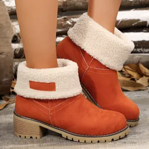 Detailed view of orange suede ankle boots featuring a white faux fur fold-over collar