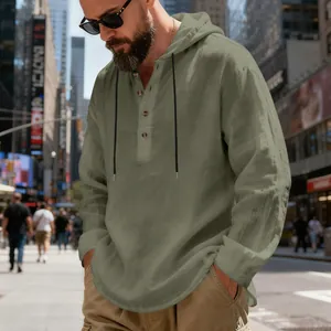 Macro view showing the breathable linen fabric and wooden buttons of the green Henley hoodie