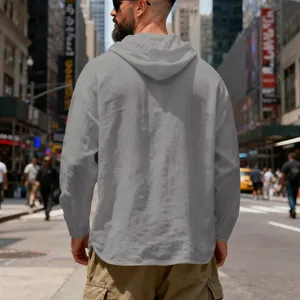 Back view of a breathable grey linen hooded shirt for men walking in an urban city street