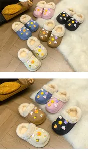 Vue détaillée de sabots d'hiver doublés de peluche avec des breloques sur tapis doux