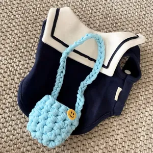 Detail of navy sailor pet shirt with light blue chunky knit crossbody bag accessory