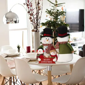 Christmas snowman family plush dolls on dining table with festive home background
