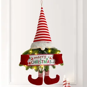 Detailansicht eines leuchtenden Weihnachts-Wichtels mit 'Merry Christmas'-Schild