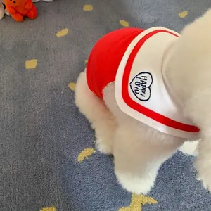 Primo piano di un piccolo cane bianco che indossa una maglietta rossa con collo alla marinara