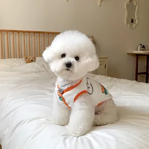 Chaleco polar blanco suave para mascota con borde naranja en un pequeño perro Bichon Frisé