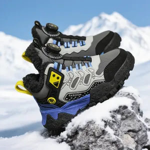 Warm winter snow boots with plush lining and rotary lacing system on snowy rocks