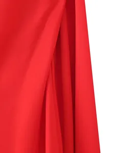 Detailed macro view showing the luxurious red silk satin fabric texture of the dress