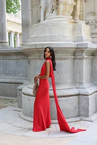 Elegant red satin halter neck dress with long trailing scarf detail in classic setting