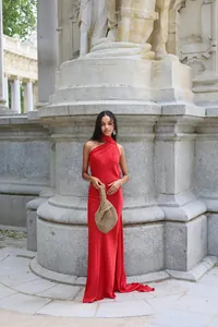 Elegant red satin one-shoulder maxi dress shown in a classical architectural setting.