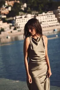 Detailed view of an elegant satin sleeveless midi dress with a cowl neck design.