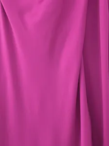 Detailed macro view of fuchsia silk-satin fabric showing smooth texture and elegant sheen.