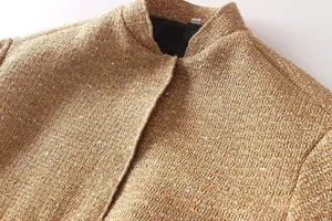 Close-up of a stylish gold tweed jacket featuring sparkling sequin embellishments