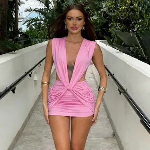 Elegant pink deep V-neck ruched mini dress worn by a model in an outdoor setting