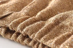 Detail shot of brown tweed jacket fabric with gold threads and silver sequins.